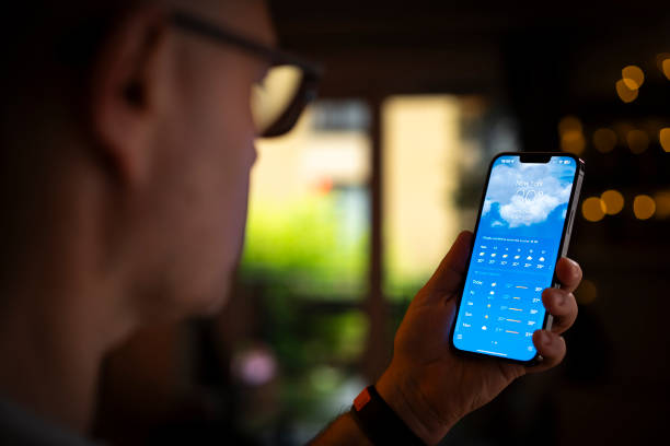 Person looking at a phone with a weather app